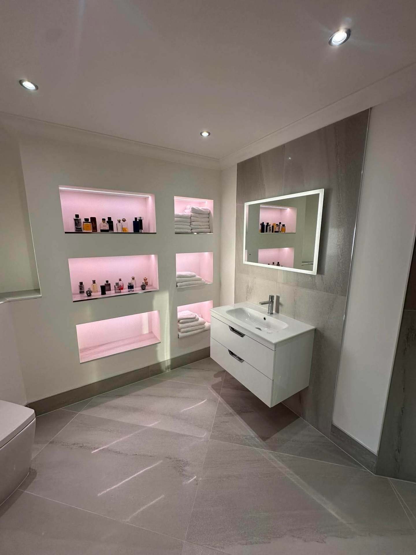 Modern bathroom with LED-lit recessed shelving and wall-hung vanity