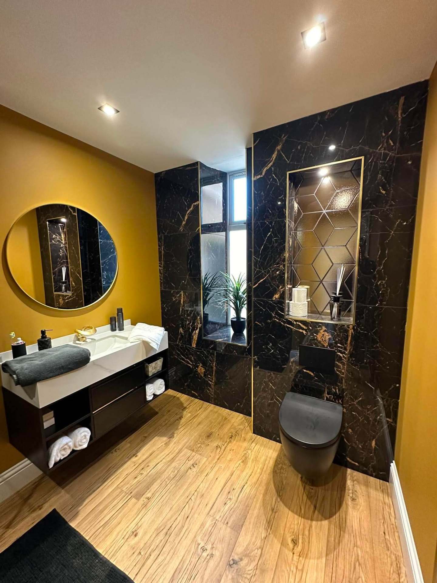 Black marble and gold bathroom with wall-hung WC